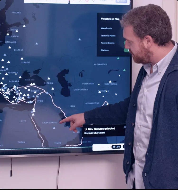 Una persona che indica una mappa su uno schermo grande