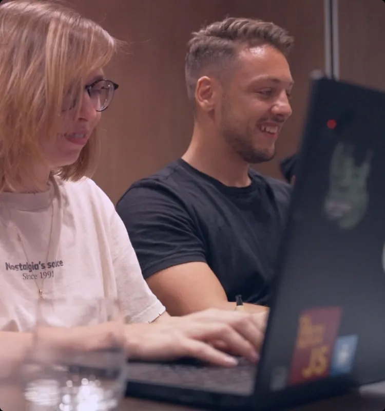 Due colleghi che lavorano affiancati ai laptop