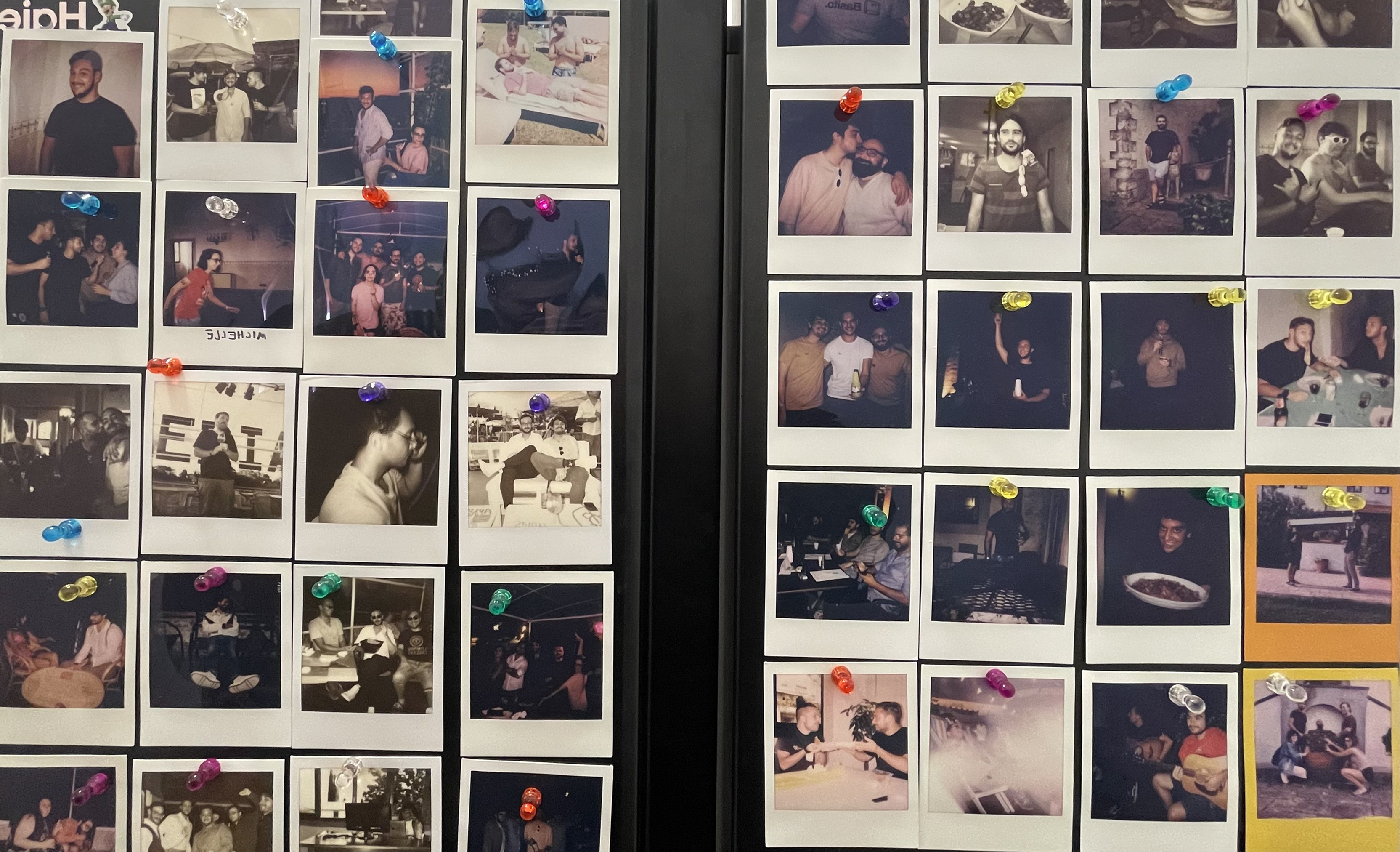 Foto polaroid attaccate a un frigo che ritraggono varie persone e momenti di moveax.